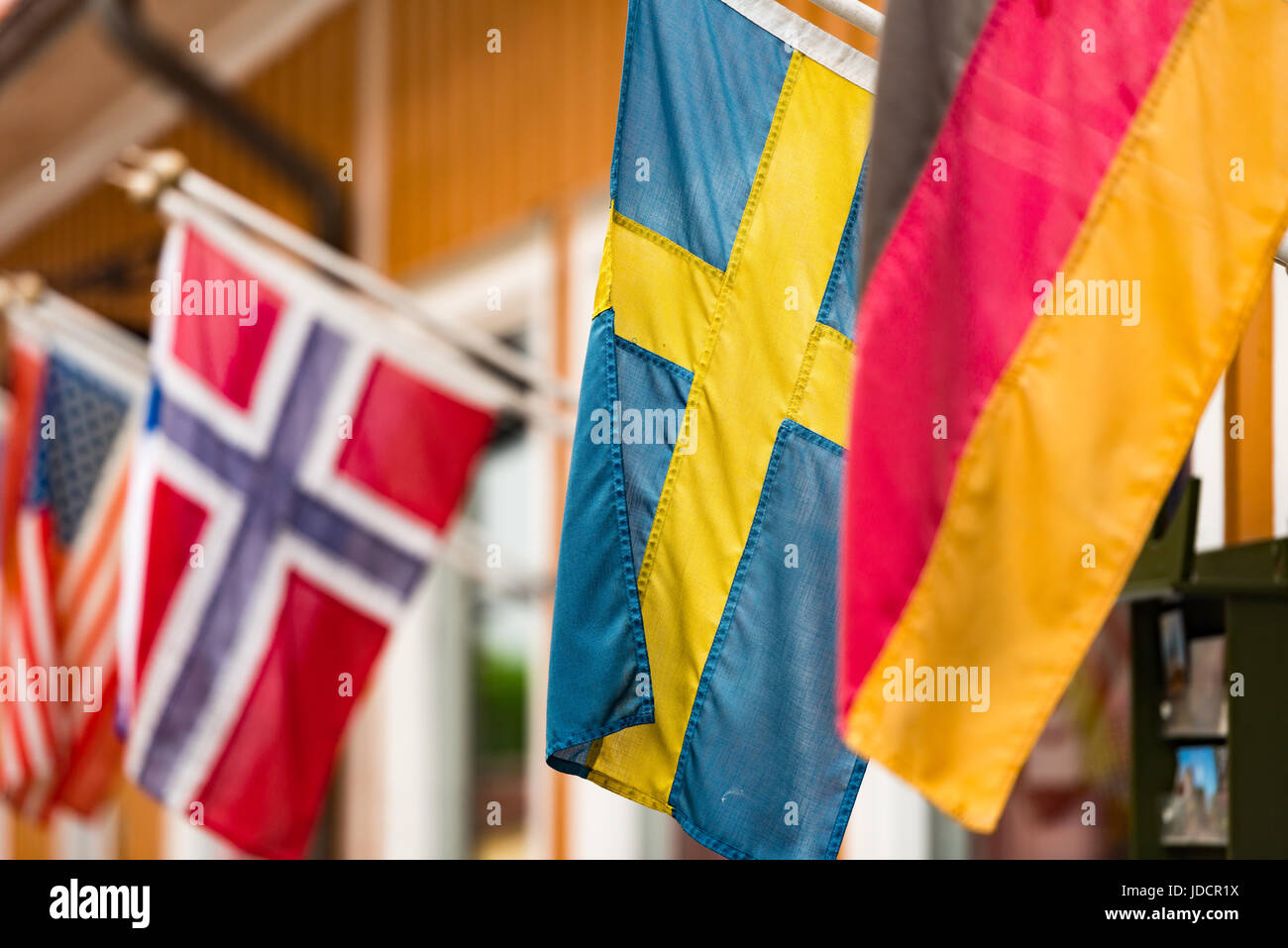 Many flags on wall of building in old town Sigtuna. Europe travel. Sweden, Scandinavia. Stock Photo