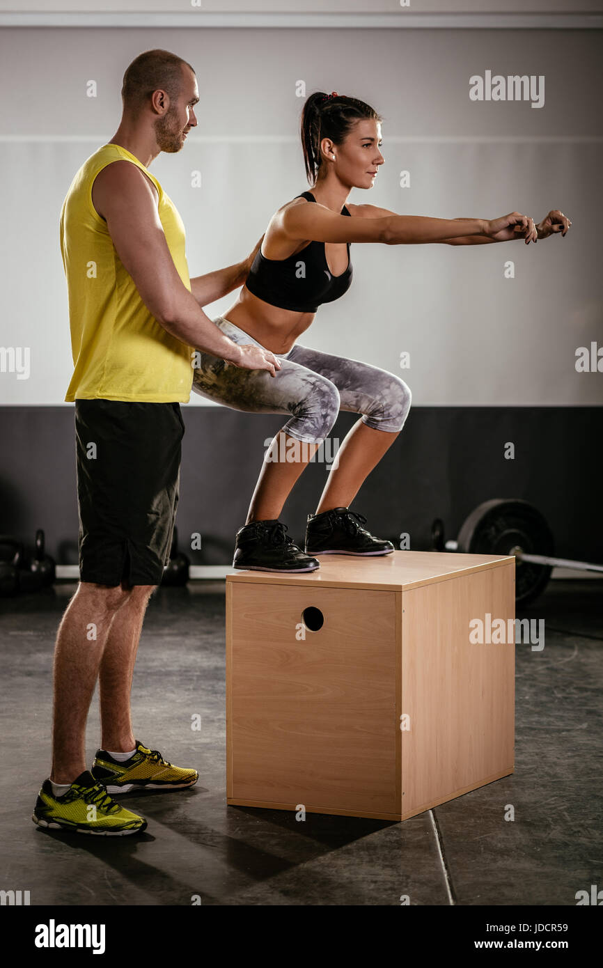 Woman exercising at the gym with a personal trainer Stock Photo - Alamy
