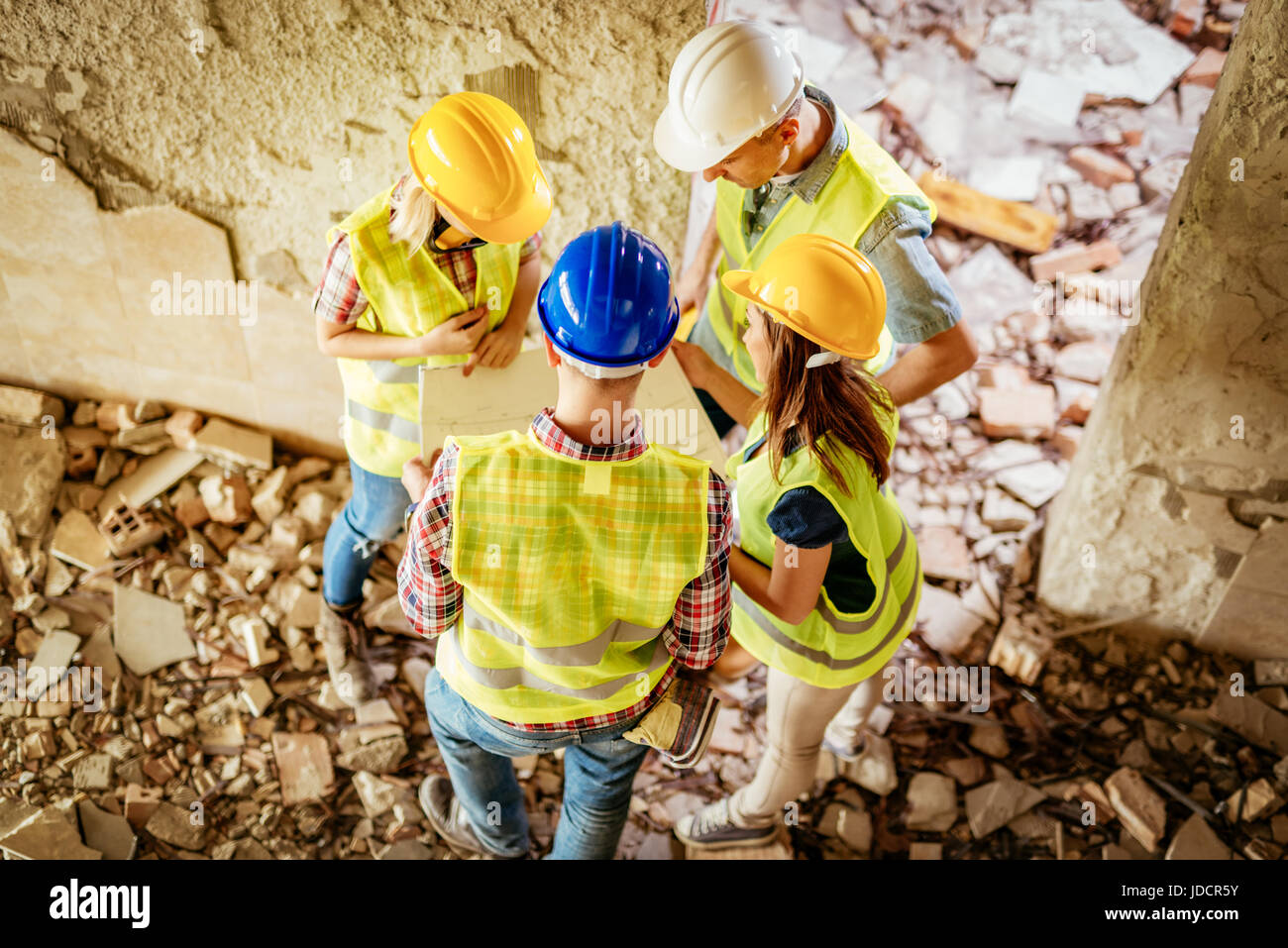 Four construction architects review plan in building damaged in the ...