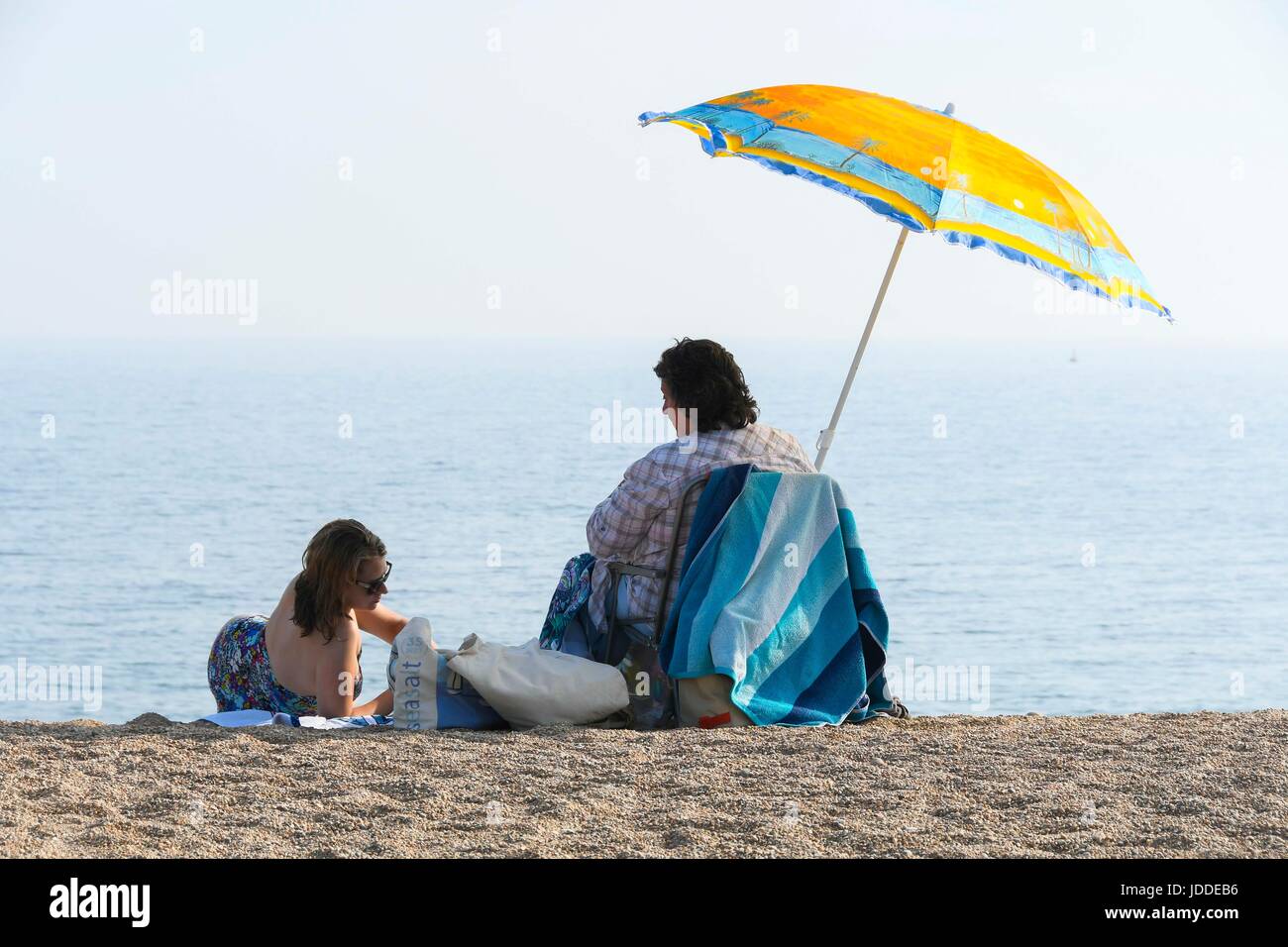 West Bay, Dorset, UK. 19th June, 2017. UK Weather. Sunbathers on the beach enjoying the clear blue skies and hot sunshine during the late afternoon at the seaside resort of West Bay in Dorset. Photo Credit: Graham Hunt/Alamy Live News Stock Photo
