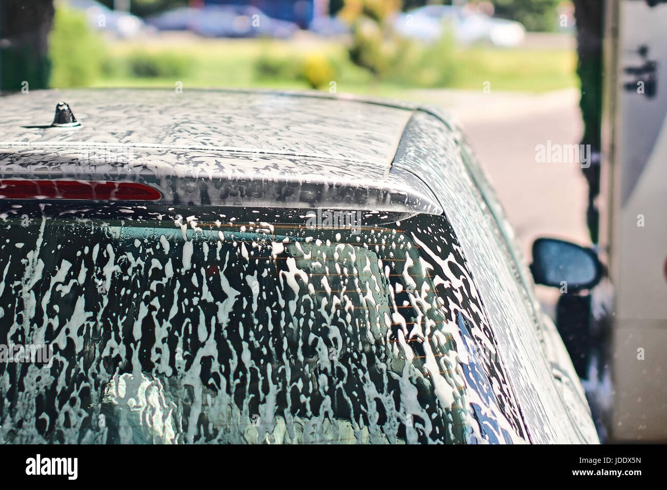 Automobile covered with foam in car wash service interior Stock Photo