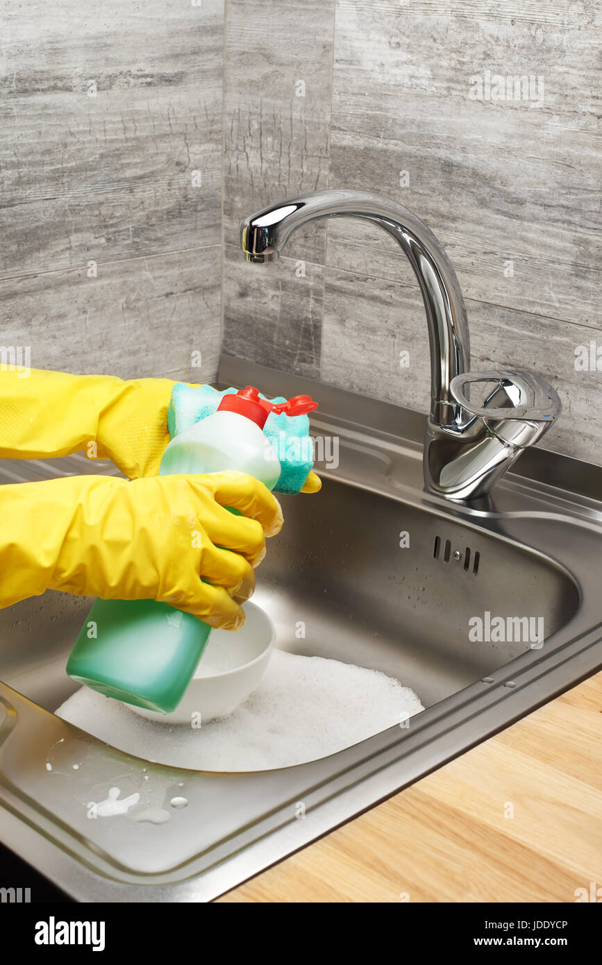 Close up of female hands in yellow protective rubber gloves washing ...