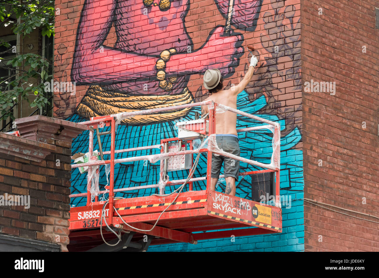 Montreal, 17 June 2017: Artist Sbu One is painting a Mural during Montreal Mural Festival Stock Photo