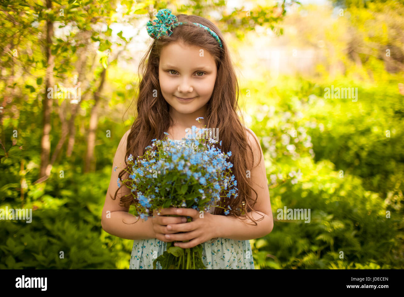 Girl with a bouquet of wild blue flowers Stock Photo - Alamy