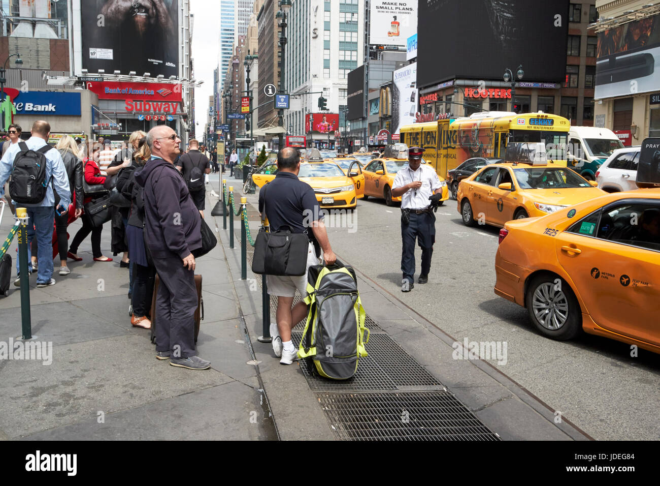 people waiting at yellow cabs stop at taxi rank on 7th avenue outside penn station New York City USA Stock Photo