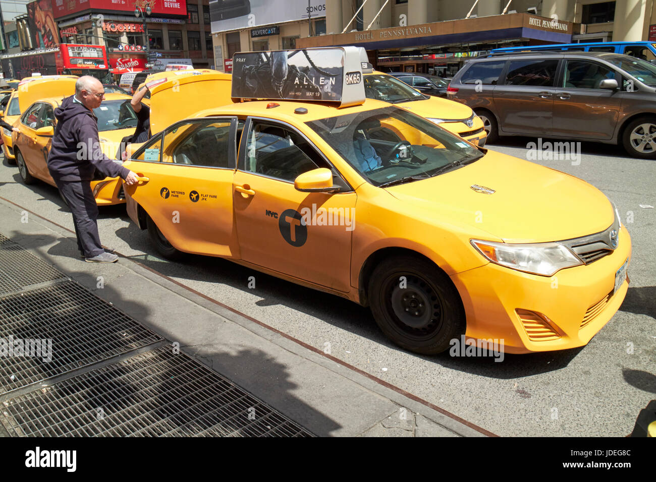 man getting in to yellow cab stop at taxi rank on 7th avenue New York City USA Stock Photo