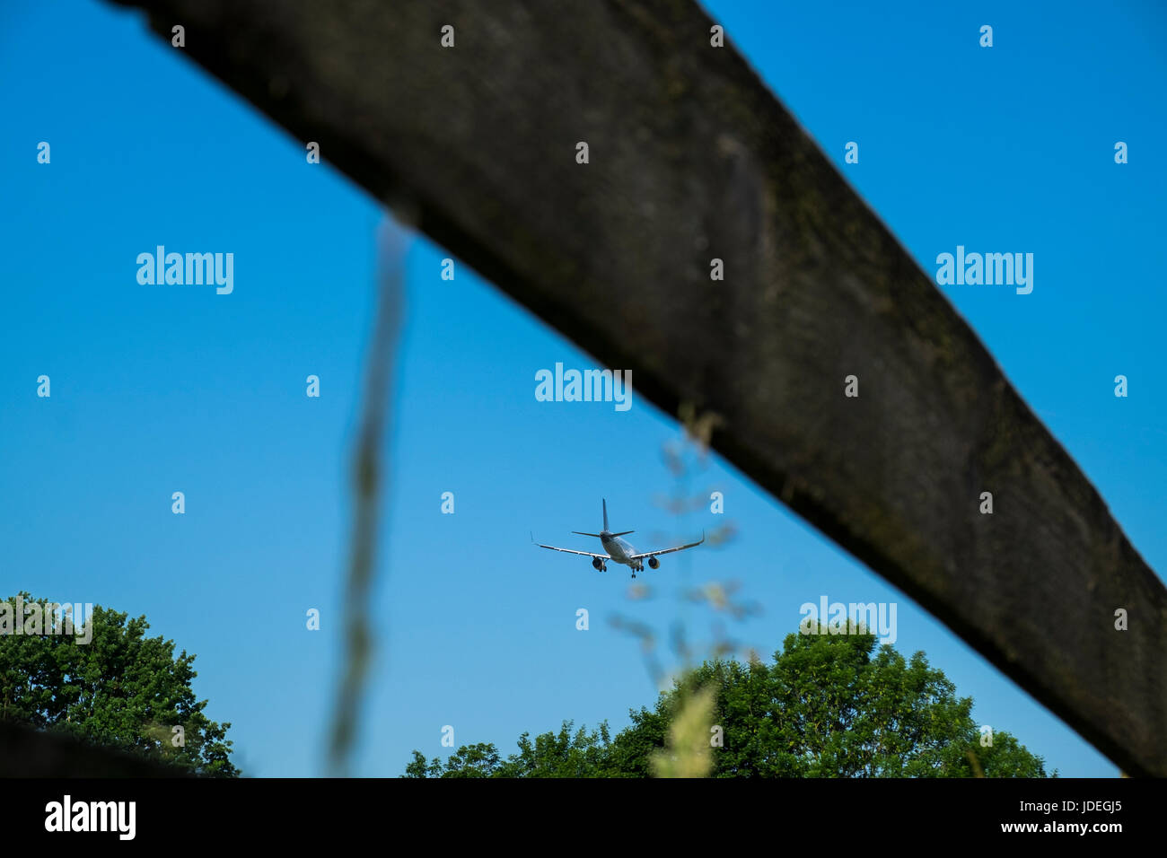 Aeroplane with landing gear down on approach to Munich airport over Schwaig district, Munich, Germany Stock Photo