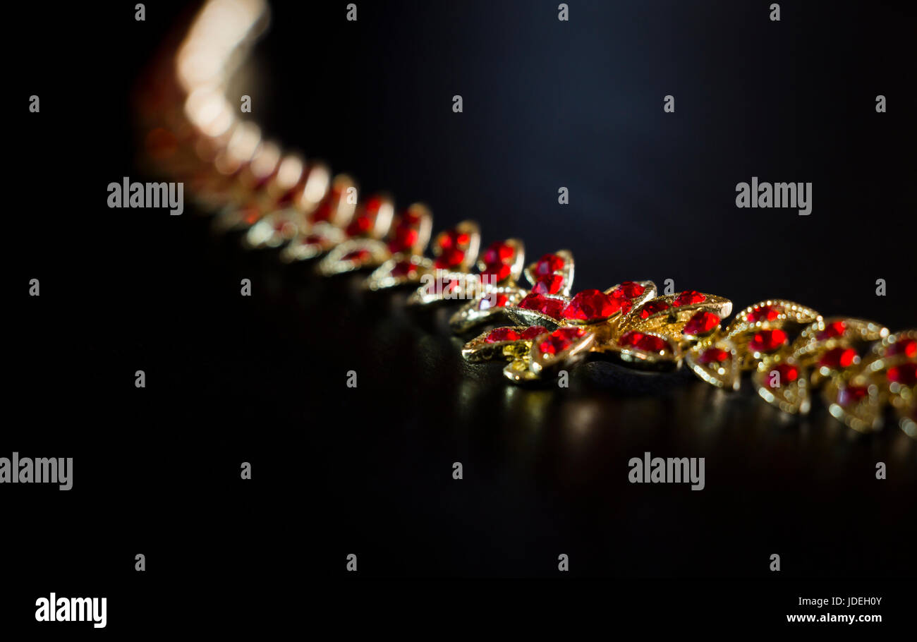 Gold necklace with red stones close-up on a black background Stock Photo