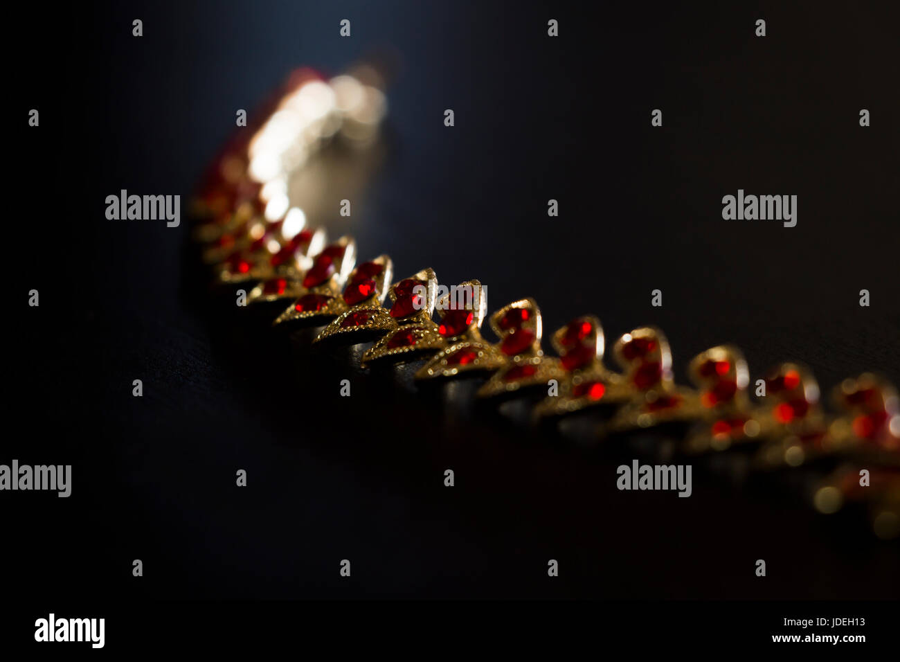 Gold necklace with red stones close-up on a black background Stock Photo