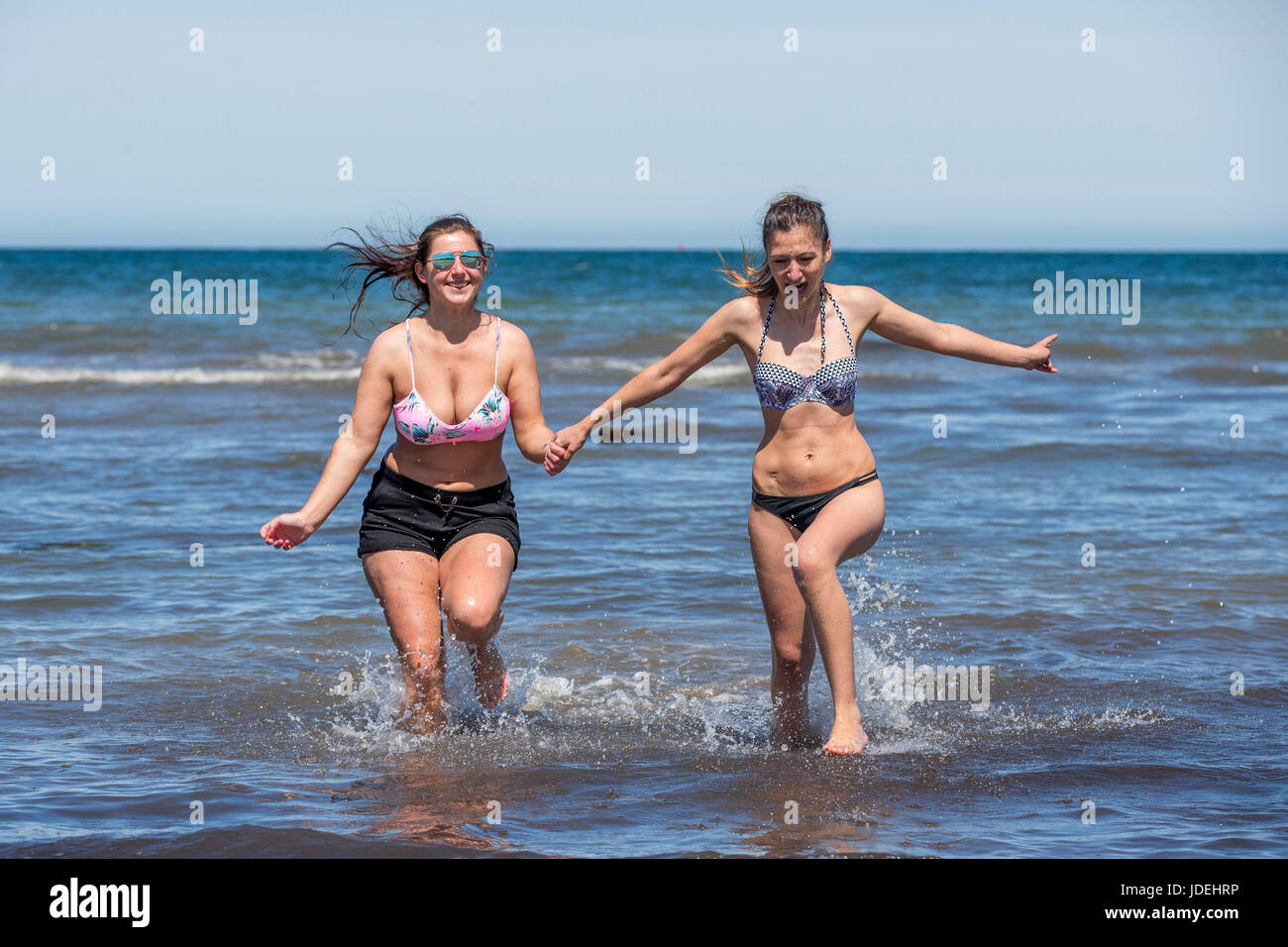 Daniela Geanta (left) and Marlena Bratu enjoying the weather at Crawfordsburn Country Park beach, Helen's Bay, Northern Ireland. Stock Photo