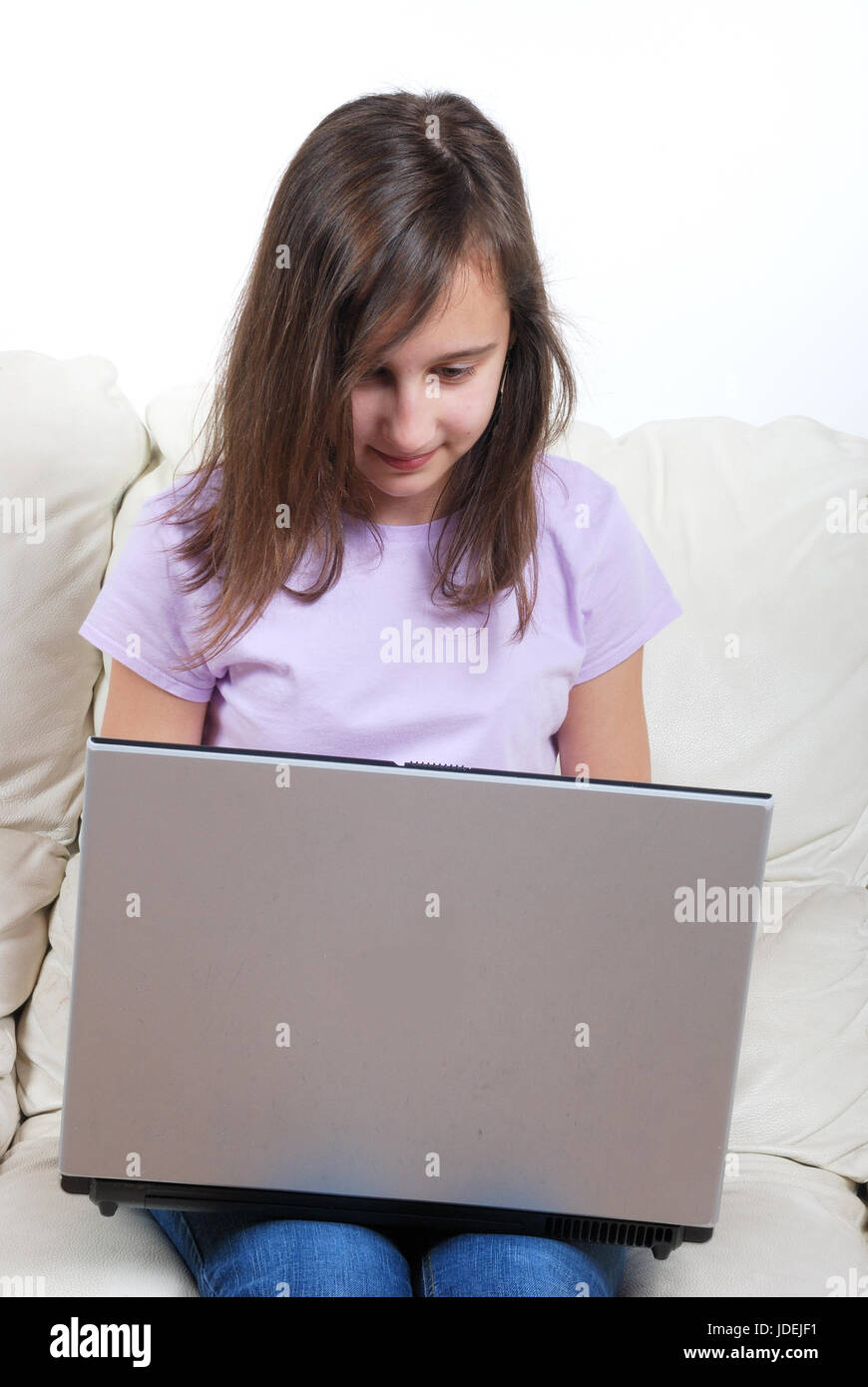 Girl sitting on the sofa and using laptop Stock Photo - Alamy