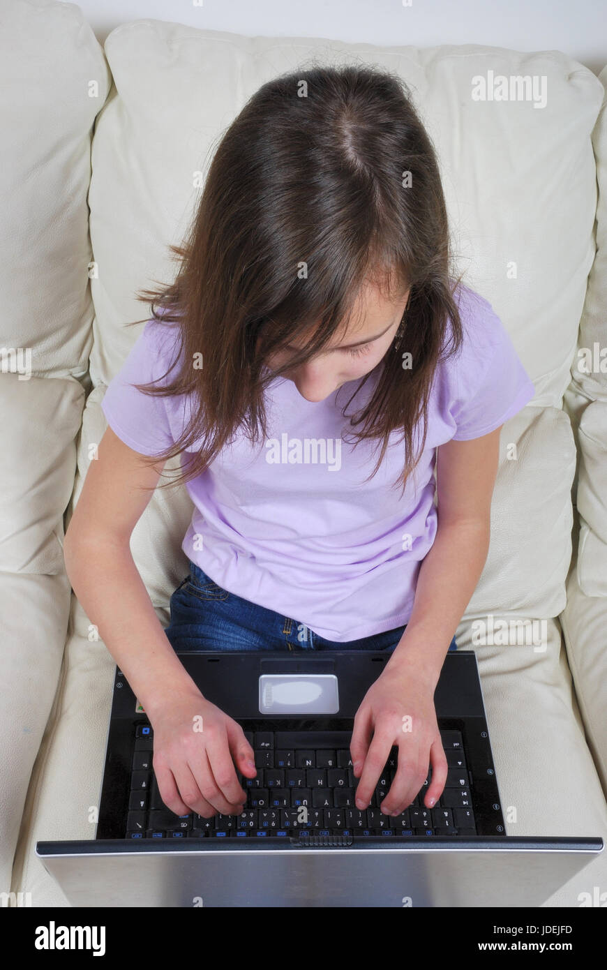 Girl sitting on the sofa and using laptop Stock Photo - Alamy
