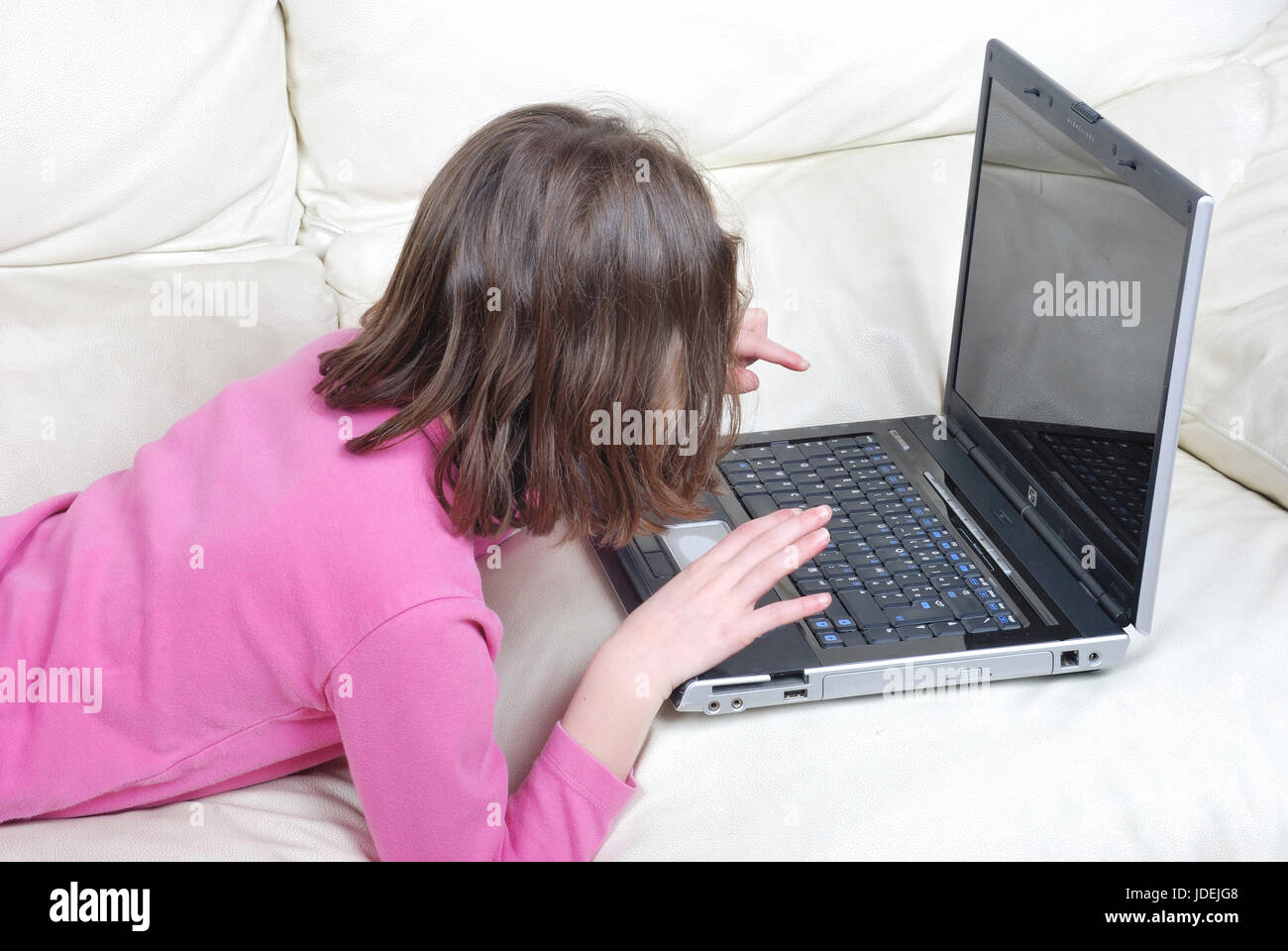 Girl lying on the sofa and using laptop Stock Photo - Alamy