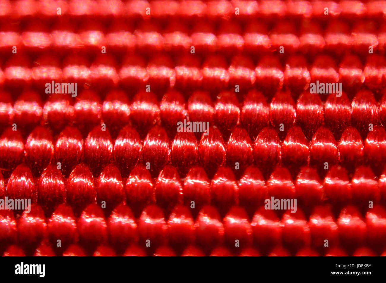 Red nylon belt close-up. Shallow depth of field. The interweaving of the fibers in the belt texture as abstract background Stock Photo