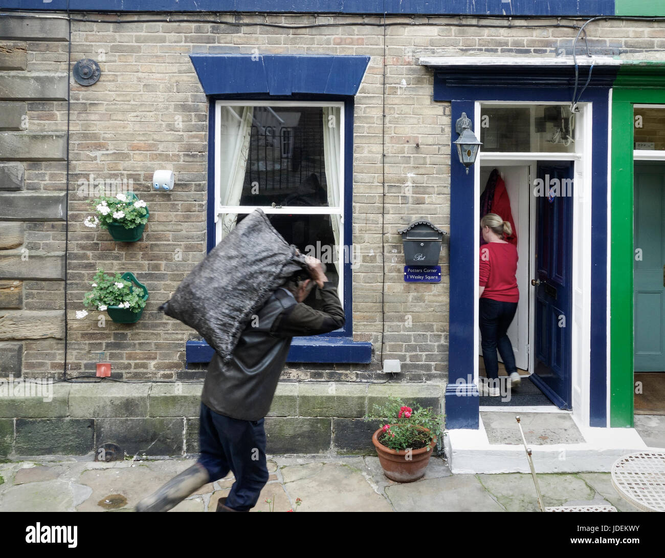 Coalman delivering coal to house in Staithes village on the North Yorkshire coast. England, UK Stock Photo