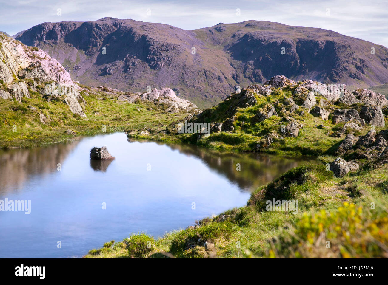 A rock reflected in the tarn at the top of Haystacks Stock Photo