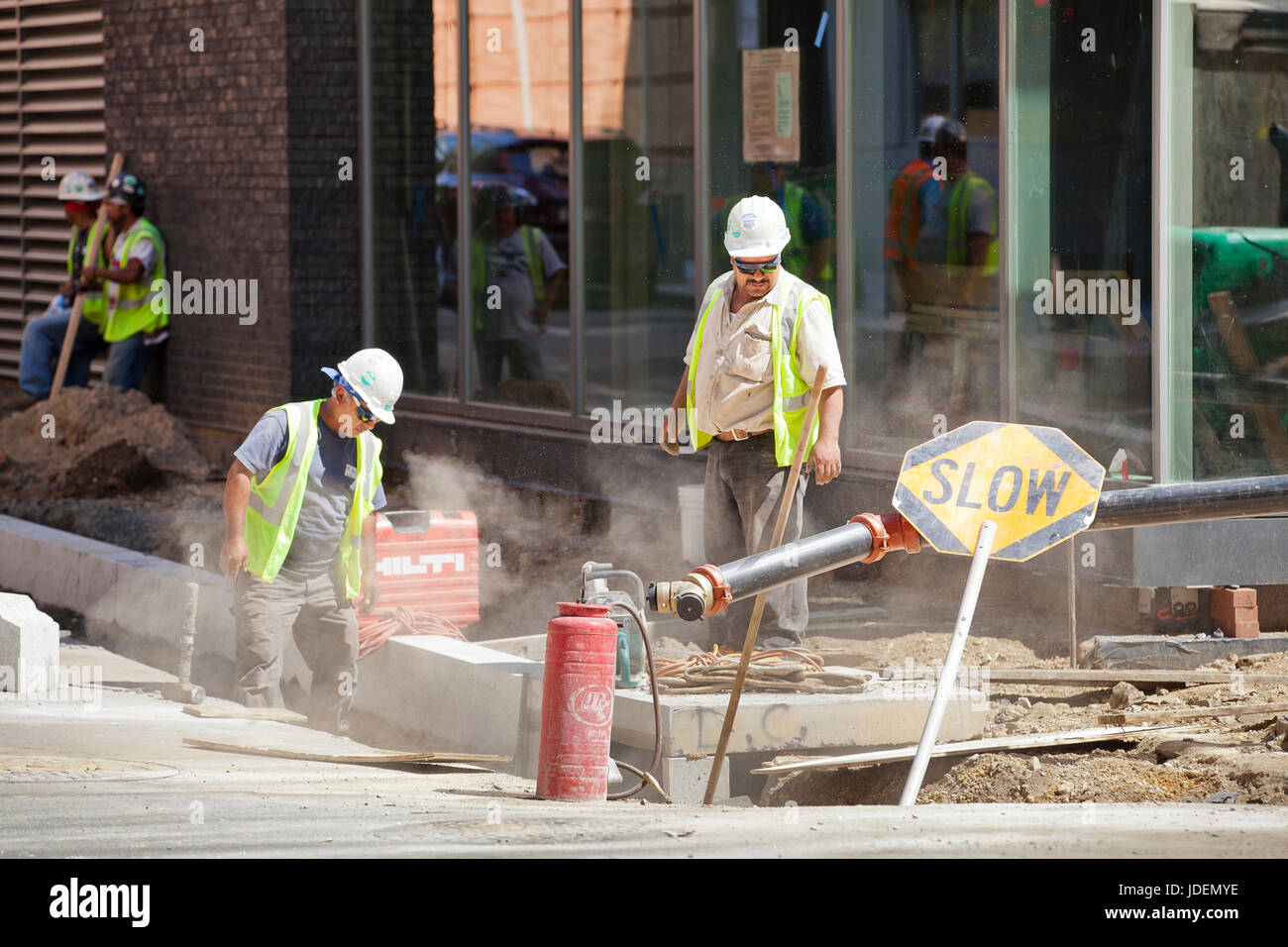 Municipal construction workers repairing a public walkway (sidewalk) - USA Stock Photo