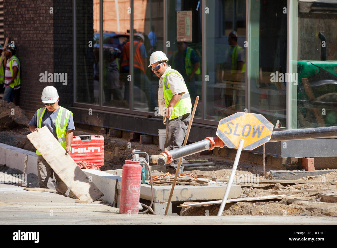 Municipal construction workers repairing a public walkway (sidewalk) - USA Stock Photo