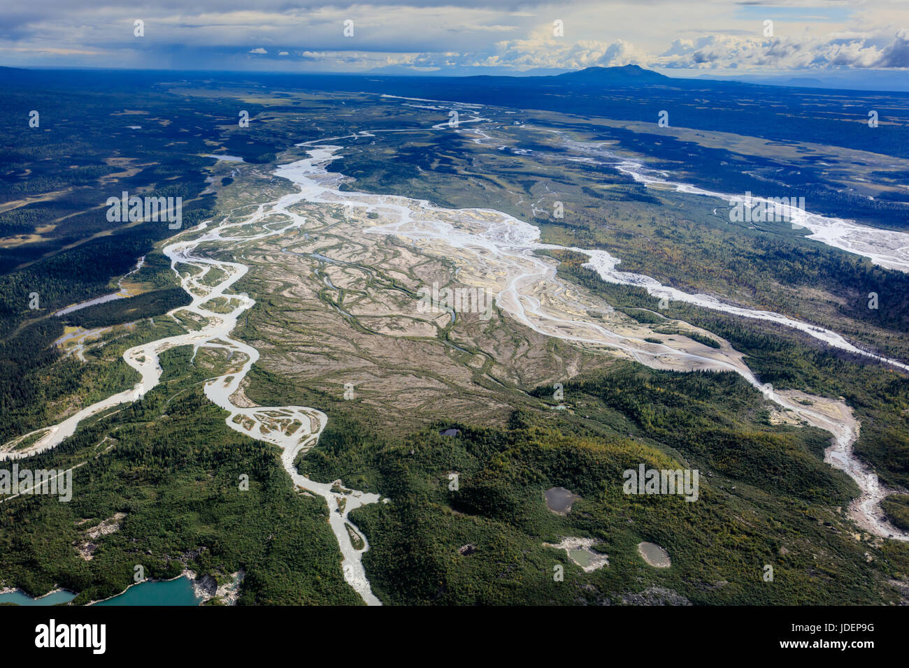 Aerial view of braided rivers flowing from glacial morain at foot of large glacier Stock Photo