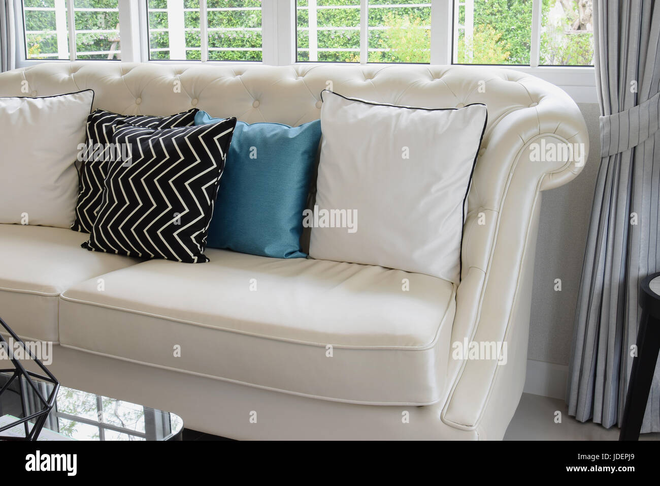 White And Blue Pillows On A White Leather Couch In Vintage Living