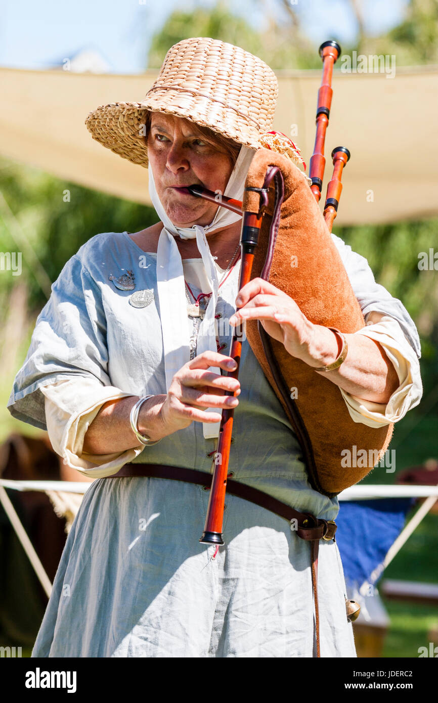 Medieval reenactment event, mature woman, dressed as medieval minstrel