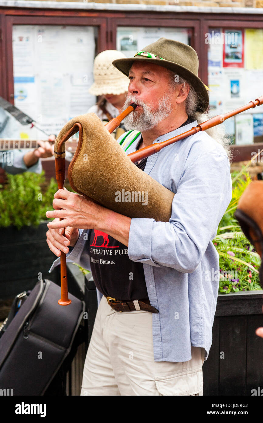 Mature Man, 50s, playing medieval bagpipes outdoors at Le Weekend event at Sandwich town, England. Stock Photo