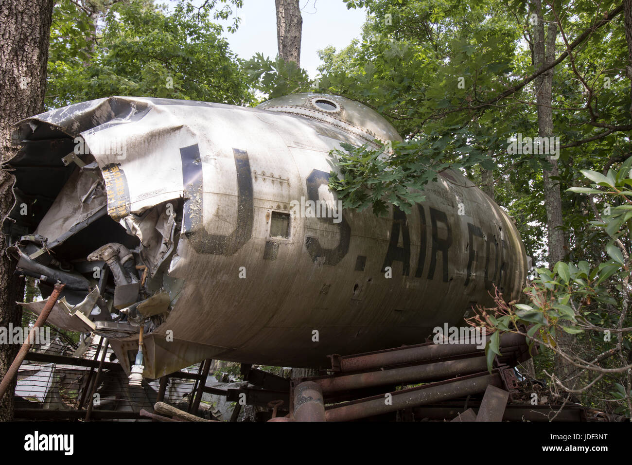 Wreckage of US Air Force fighter jet in trees of junkyard. Stock Photo
