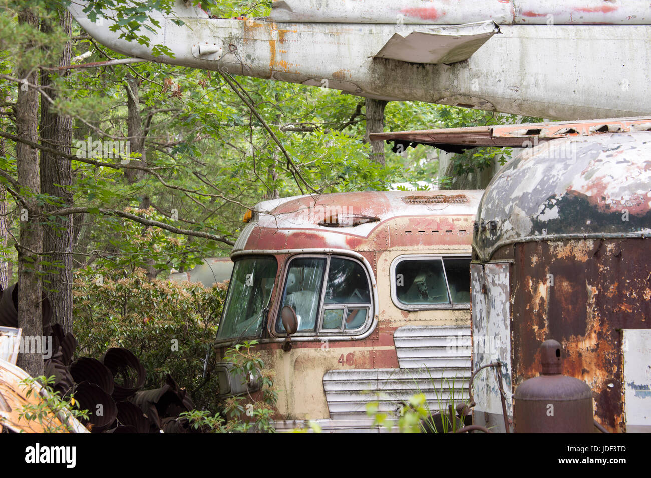 Rusting old buses and airplanes in wooded junkyard Stock Photo - Alamy