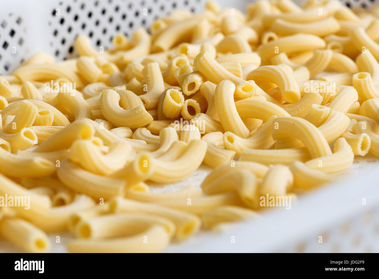 Close up of fresh handmade Italian pasta tubes on white tray Stock Photo
