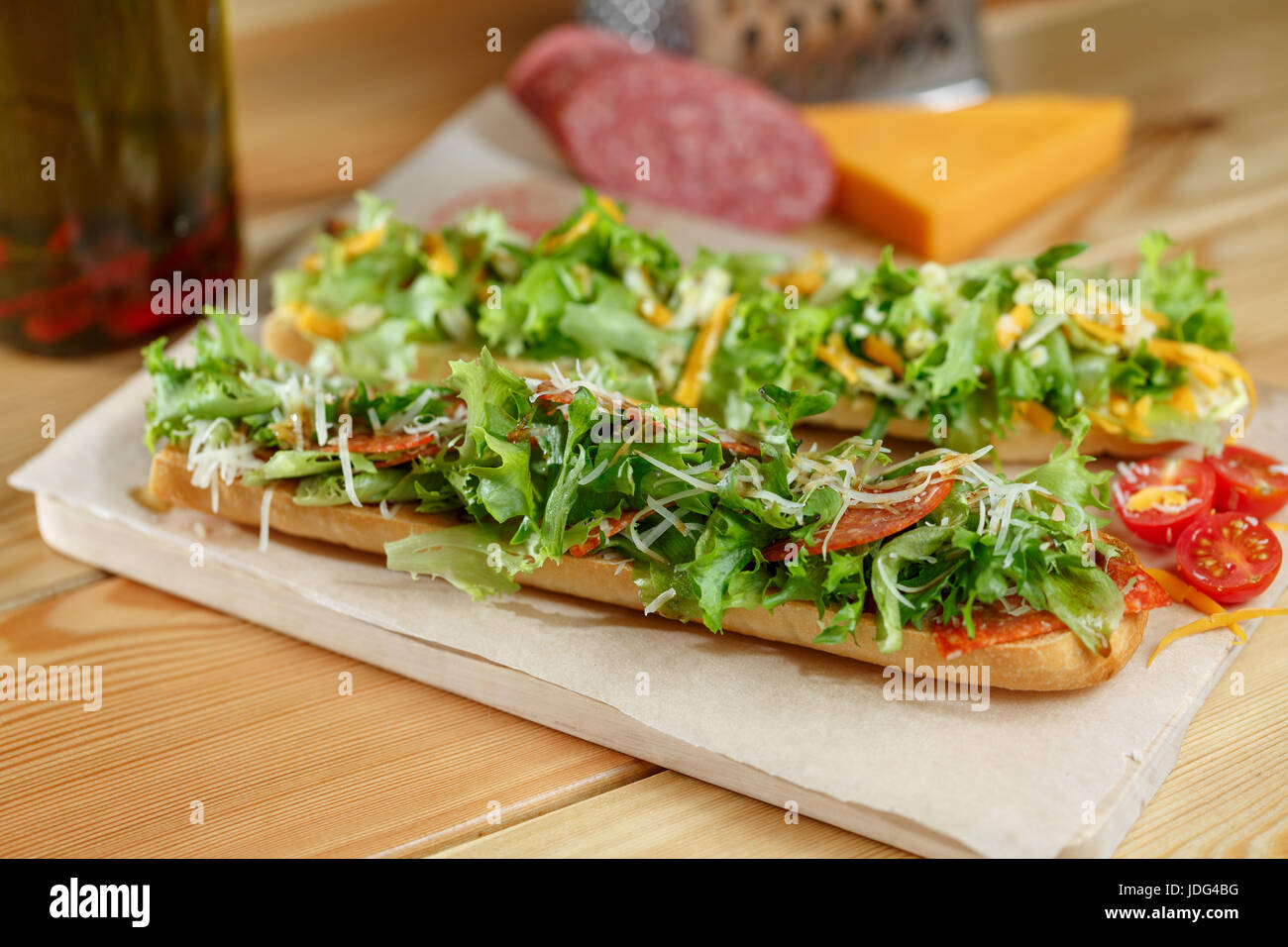 Healthy fresh crusty baguette submarine sandwich with salami, cheese
