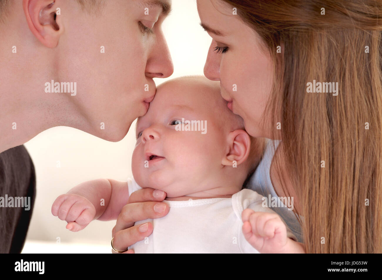 Closeup Portrait Of Beautiful Young Family With Newborn Young Parents Both Kissing Their Sweet Baby Happy Parenthood Stock Photo Alamy