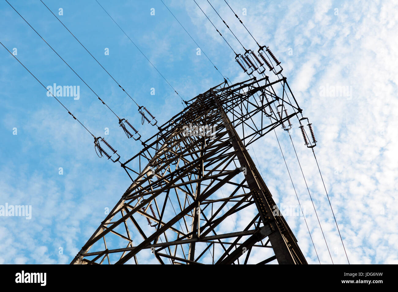 Electricity pylon against blue cloudy sky Stock Photo - Alamy