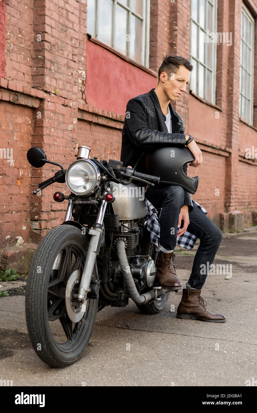 Handsome rider biker guy in black leather jacket, boots and style denim sit  on classic style cafe racer motorcycle. Bike custom made in vintage garage  Stock Photo - Alamy