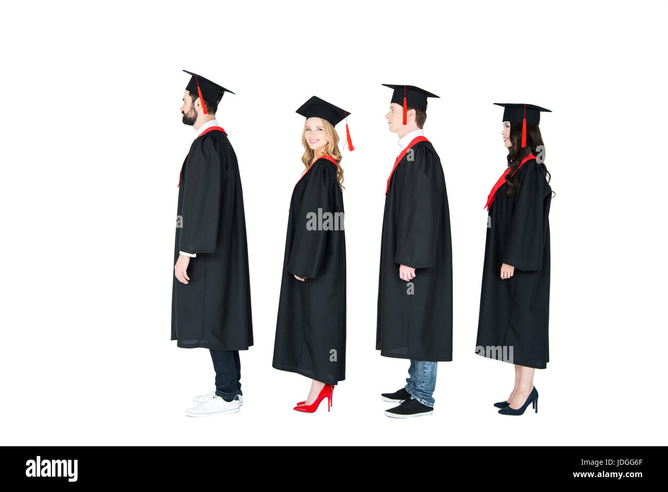 Full length side view of students in academic caps and graduation gowns standing in a row Stock Photo