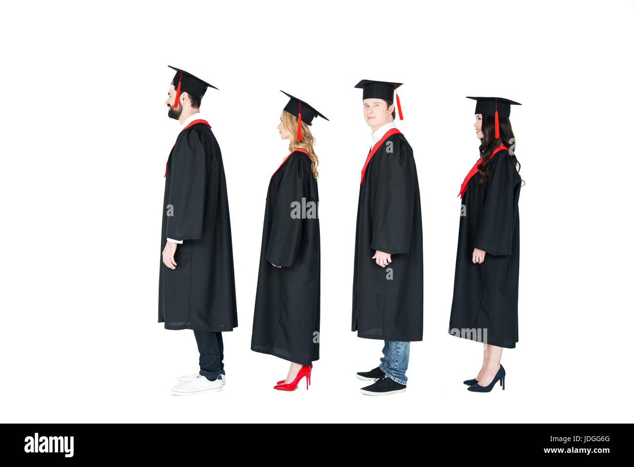 Full length side view of students in academic caps and graduation gowns standing in a row Stock Photo