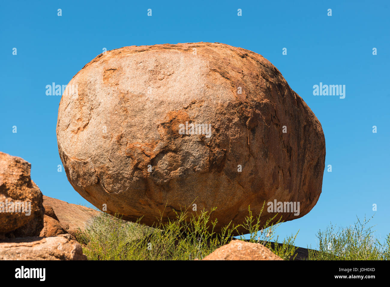 Devils Marbles boulders of red granite are balanced on bedrock