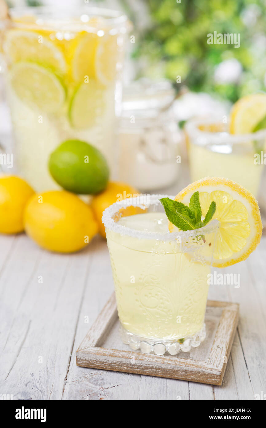 Refreshing homemade lemonade on a rustic outdoor table in bright light. Stock Photo