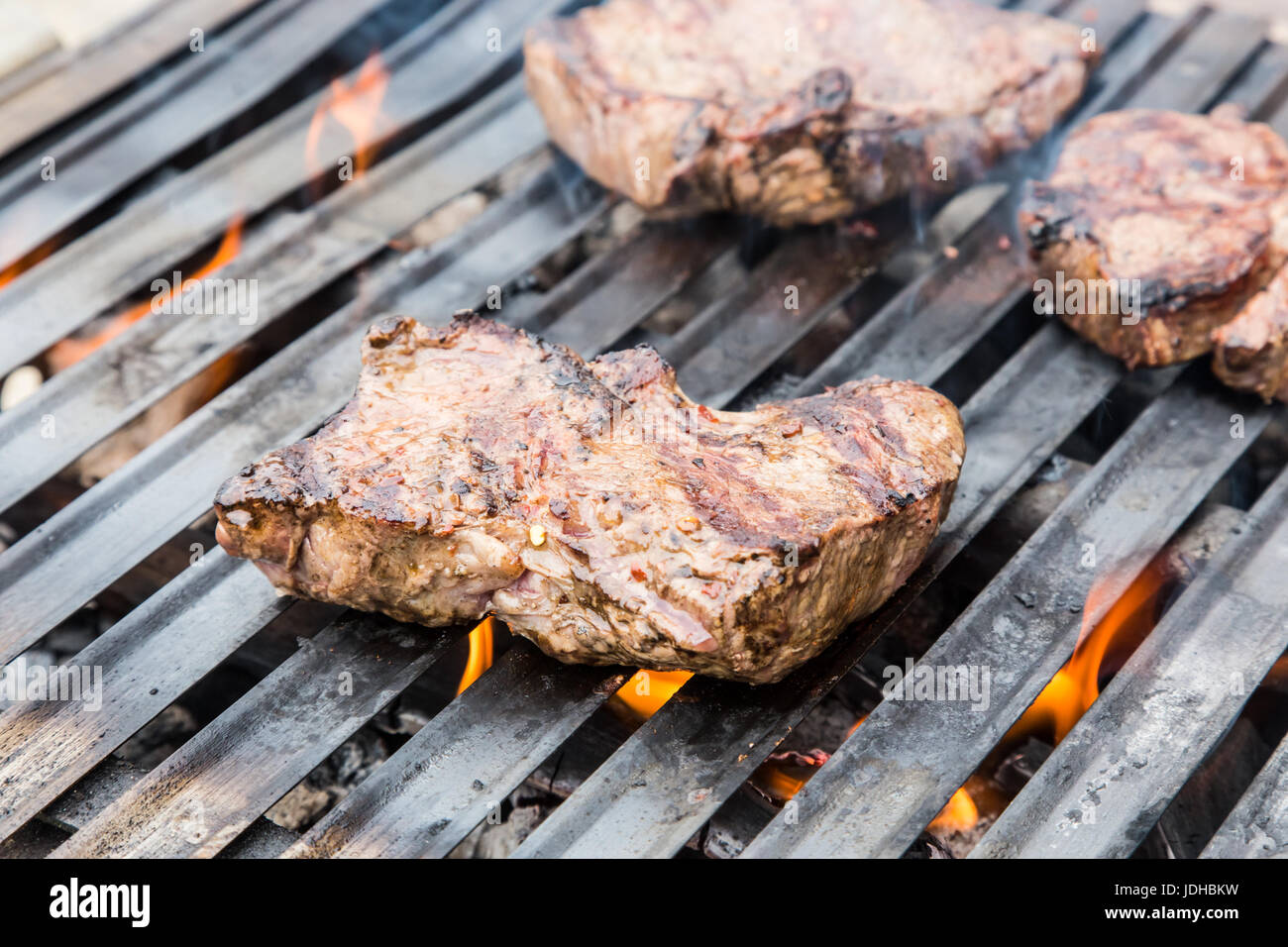 Beef steaks on the grill with flames Stock Photo - Alamy
