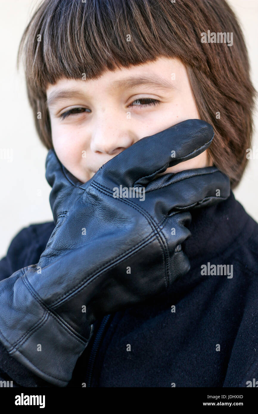 Boy with Black Gloved Hand on Face Stock Photo