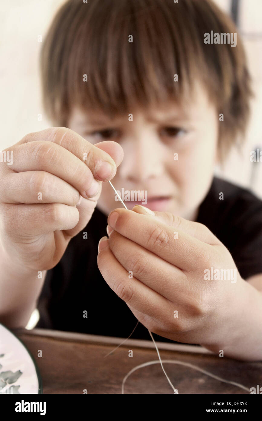 Little Boy making a necklace Stock Photo Alamy