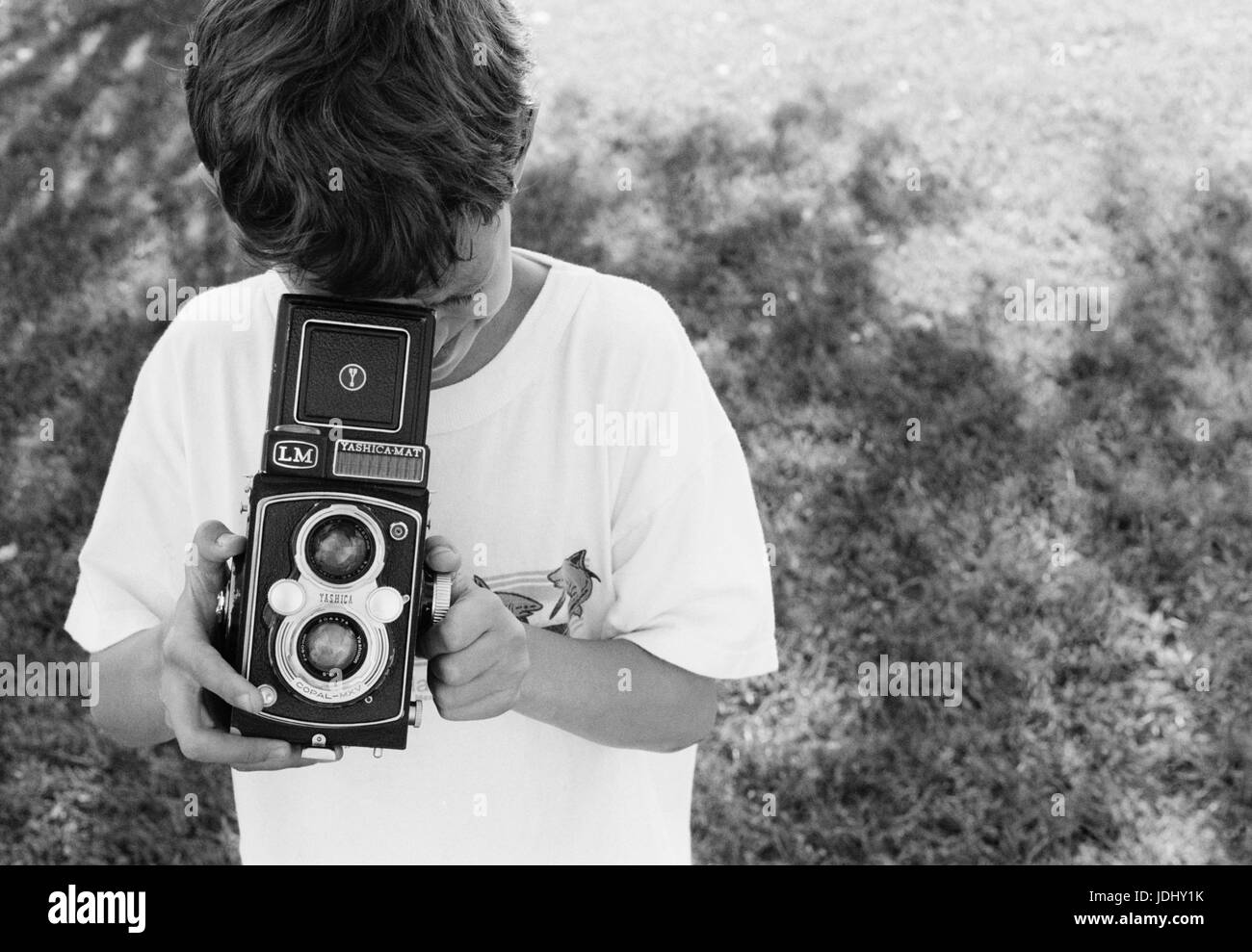 Young boy child taking a picture photograph with a medium format camera Stock Photo