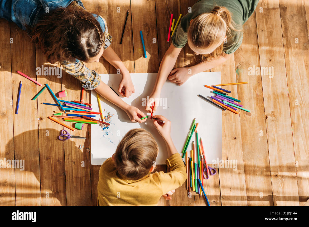 cute kids drawing on paper with pencils while lying on floor Stock ...