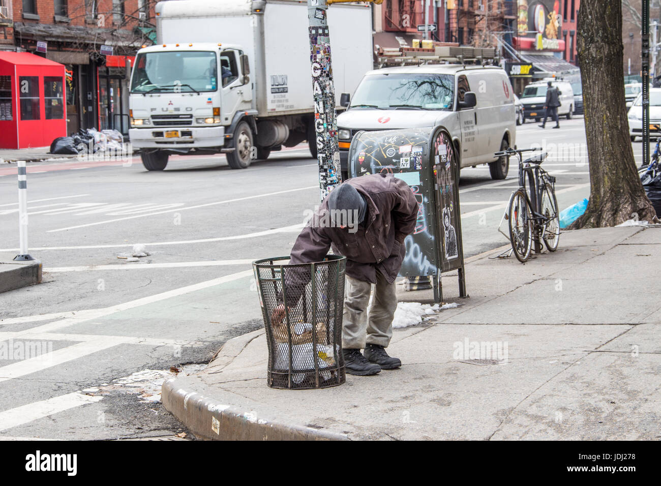Homeless man picking for scraps in the East Village, Manhattan, New York CIty, USA Stock Photo