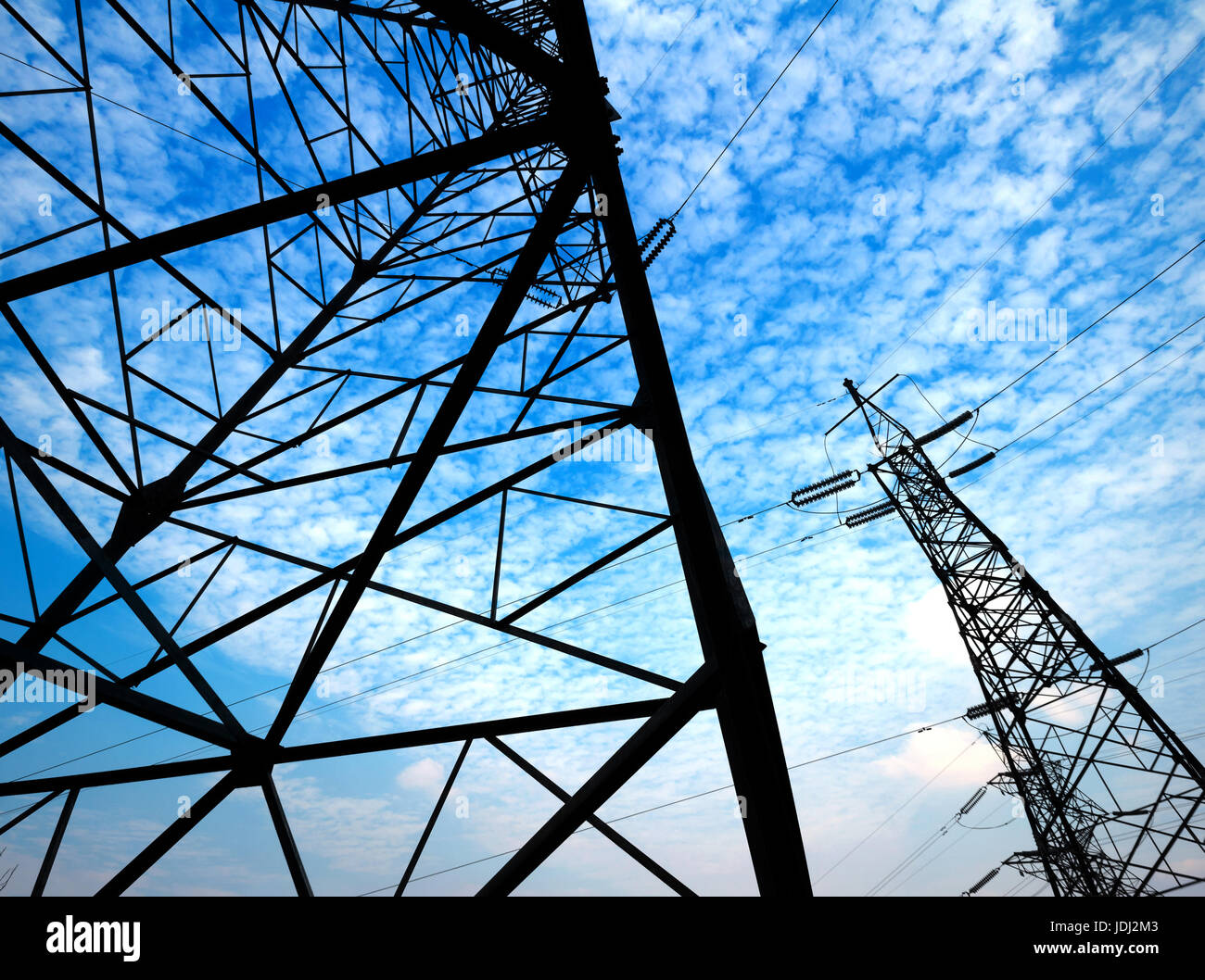 Electricity pylon against blue cloudy sky Stock Photo - Alamy