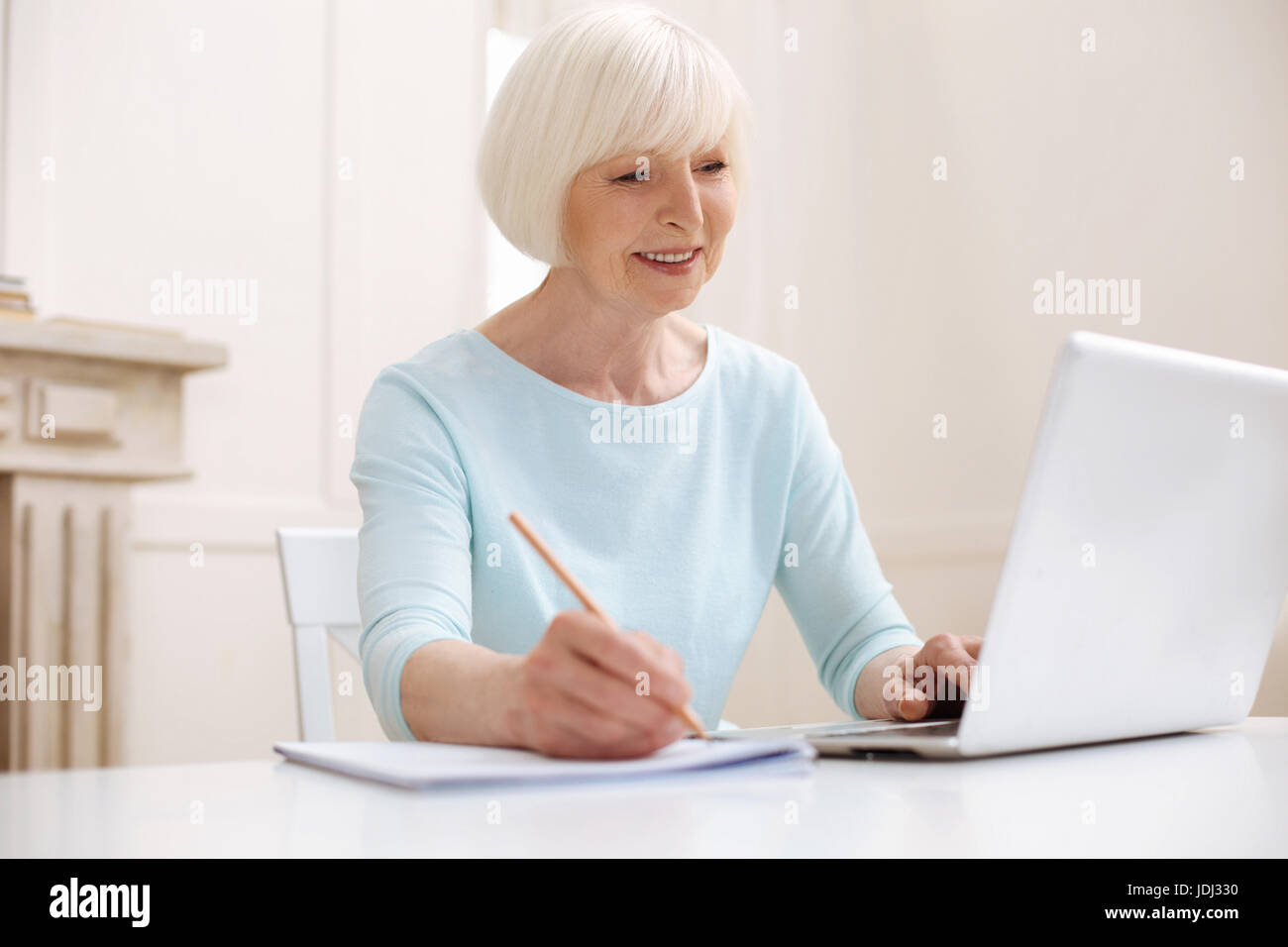 Intelligent elderly lady reading an article Stock Photo