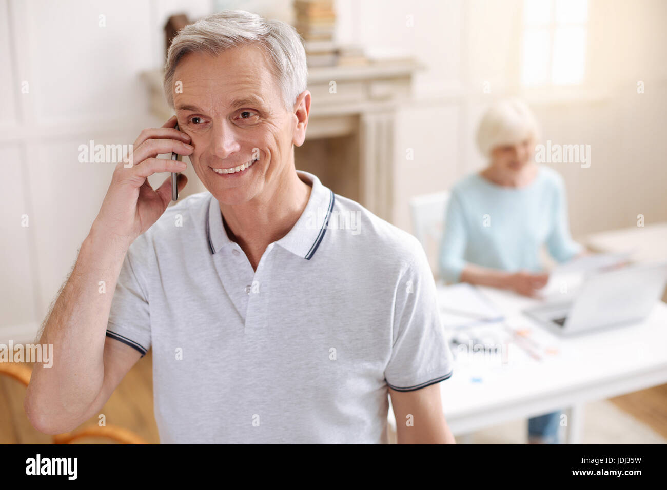 Enthusiastic elderly man calling his friend Stock Photo
