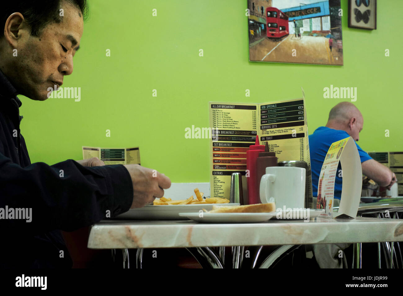 Male eating in a “greasy spoon” cafe fryup breakfast London UK Stock