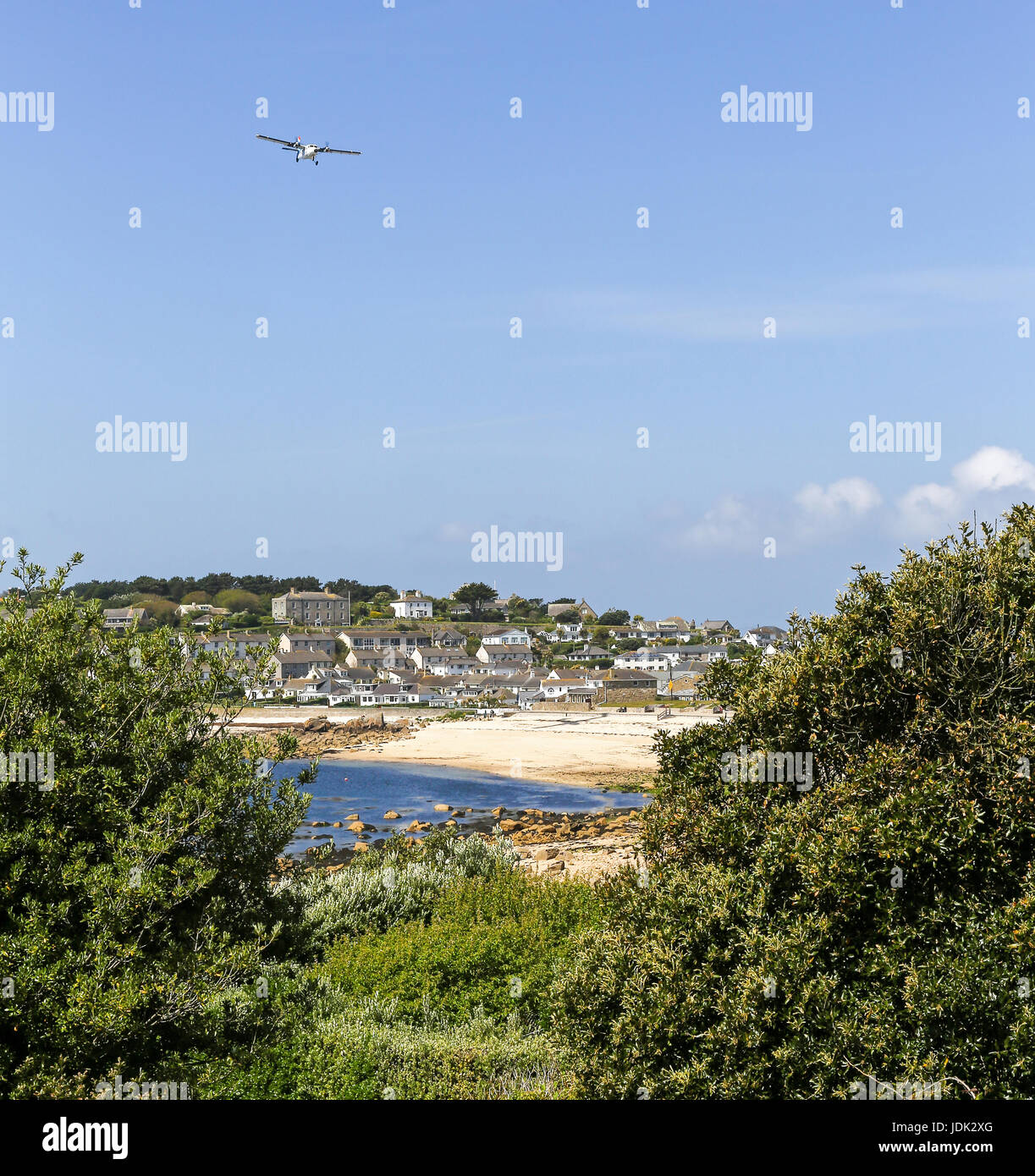 A plane coming in to land at St. Mary's airport over Porthcressa beach and Bay Hugh Town, St. Mary's Island, Isles of Scilly, Cornwall, England, UK Stock Photo