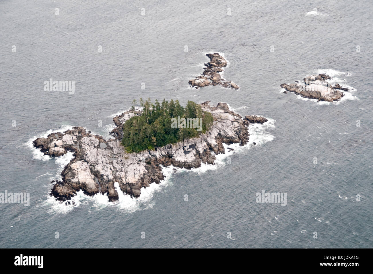 Aerial view of a small rocky uninhabited islet at low tide in the North Pacific in the Great Bear Rainforest, central coast, British Columbia, Canada. Stock Photo