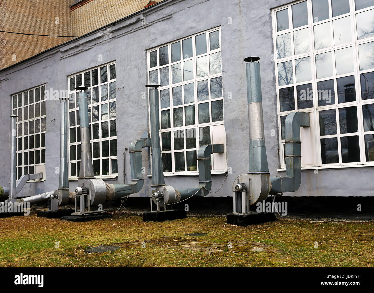 Industrial facilities with technical support devices and vent apparatus on the wall of the big industrial building Stock Photo